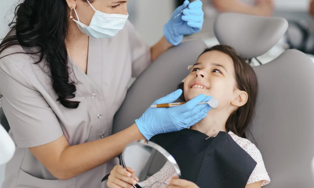 Dentista para niños en Miami evaluando diente permanente detrás del diente de leche